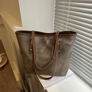Retro canvas tote bag with brown leather handles and gold rivets in a lifestyle scene