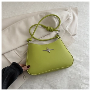 Detail view of avocado green leather shoulder bag with silver star ornament and knot strap