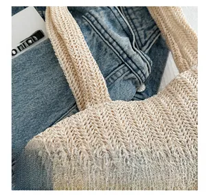 Dettaglio borsa shopper beige intrecciata con motivo a spina di pesce a V e consistenza