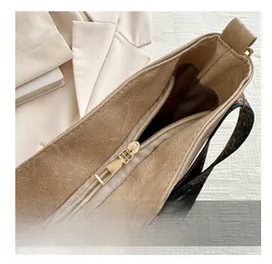 Detailed close-up of the smooth golden metal zipper and textured faux leather of the bag