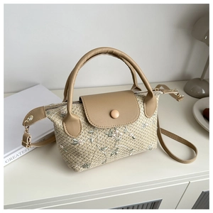 Detail of floral embroidery on a beige woven handbag with brown faux leather strap