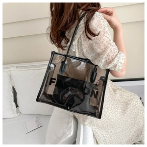 Close-up of transparent PVC tote bag with black leather trim and internal fashion pouch