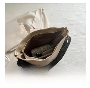 Spacious beige tote interior showing storage for umbrella and wallet with ethnic strap