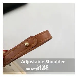 Detail showing an adjustable brown lychee leather shoulder strap with golden metal studs