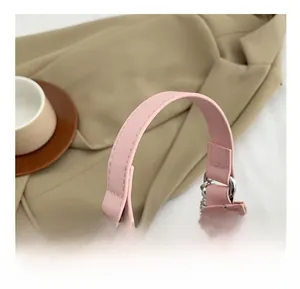Close-up of pink PU leather wide handle with detailed stitching and silver rings