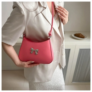 Pink hobo bag with a silver metallic bow detail styled with a white blazer outfit