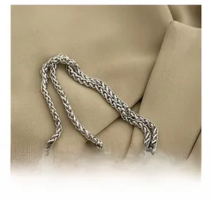 Detail of silver woven metal chain strap with pink leather on khaki fabric texture