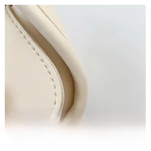 Close-up of off-white faux leather fabric with smooth texture and reinforced stitching
