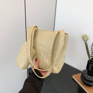 Minimalist beige woven straw tote bag with matching coin purse and wide shoulder strap