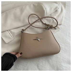 Detail of apricot shoulder bag featuring a silver star logo and knotted strap design
