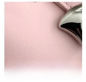 Close-up of pink litchi grain leather texture and polished silver metal hardware