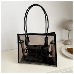Detail of transparent tote bag featuring black fashion lettering and inner pouch