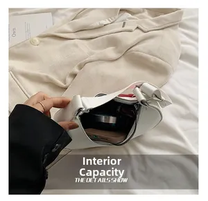 Detail view of the white half-moon bag interior showing space for phone and makeup