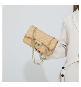 Close-up of beige quilted leather handbag with gold chain strap and metal turn-lock closure