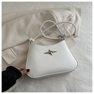 Detail of white leather shoulder bag with silver star emblem and knotted strap detail