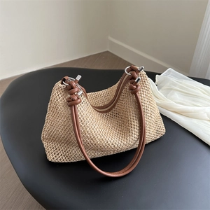 Chic beige woven straw handbag with brown leather straps and metallic rings for summer