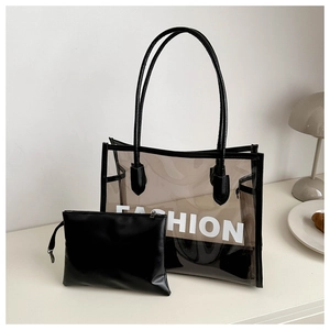 Detailed view of transparent grey tote bag with FASHION print and black leather pouch