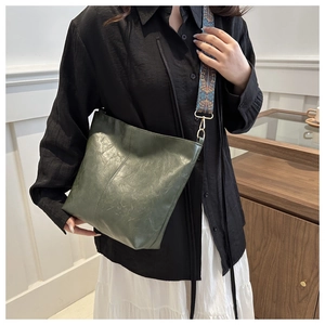 Detail of dark green tote bag featuring a wide ethnic style patterned fabric shoulder strap