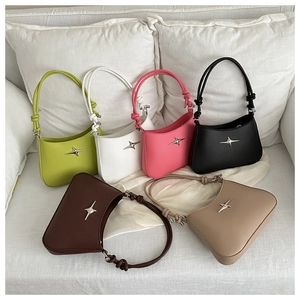 Detail of chic underarm bags with star hardware and knotted straps in various colors