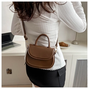 Brown semi-circle saddle bag styled on a female model for casual everyday wear