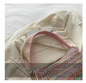 Détail du sac à main tissé coloré avec broderie papillon et bandoulière perles