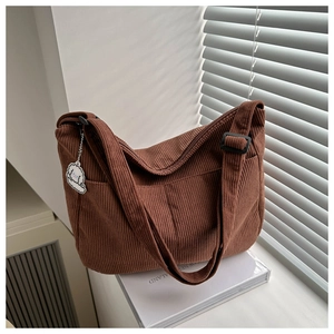 Detail of coffee brown corduroy tote bag texture with adjustable strap and cute puppy charm