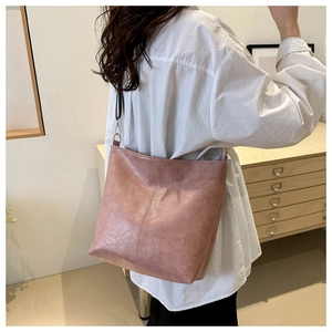 Side view of a vintage pink tote bag with marble-textured faux leather and black straps