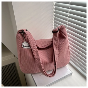 Close-up of pink corduroy tote bag texture with cute puppy pendant and adjustable strap