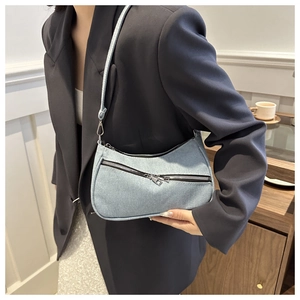 Vista dettagliata della borsa sottobraccio in denim azzurro con doppia cerniera alla moda