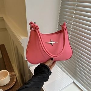 Pink leather underarm bag with a knotted handle and star logo shown in an indoor setting
