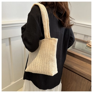 Dettaglio della borsa tote intrecciata bianco sporco con trama diagonale e tracolla