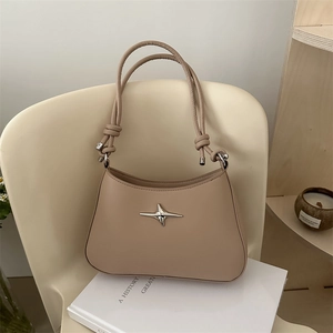 Minimalist beige leather underarm bag with star emblem and knotted handle detail