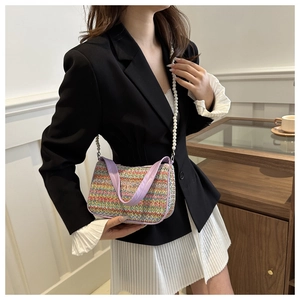 Close-up of colorful straw bag featuring butterfly pattern and pearl chain strap
