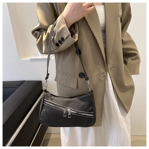 Dettaglio della borsa hobo in denim nero con cuciture bianche a contrasto e doppia zip