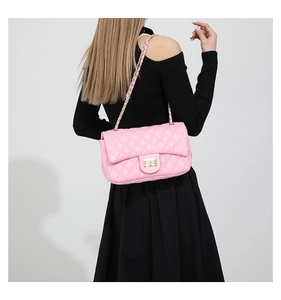 Detail of pink quilted leather shoulder bag with gold twist lock and chain strap