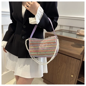 Detailed embroidery of white butterfly on colorful woven crossbody bag with pearl chain
