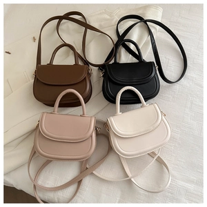 Four elegant saddle bags in brown, black, beige, and cream with gold metal hardware