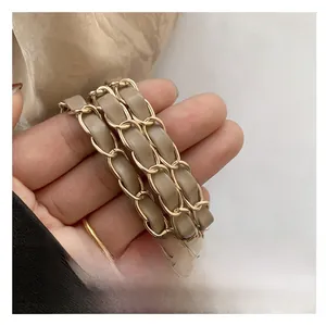 Detail of light brown leather and gold metal chain braided replacement handbag strap