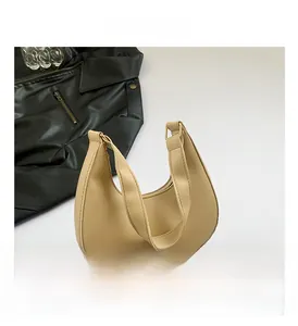 Gros plan détaillé d'un sac hobo beige en forme de lune avec boucles en métal doré chic