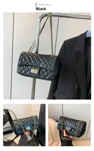 Detailed close-up of a black quilted crossbody bag with gold chain and twist lock