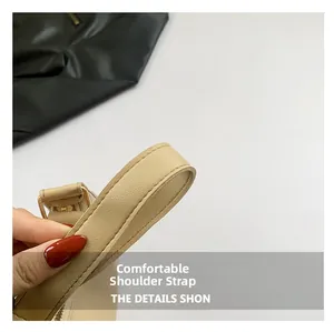 Détail de la bandoulière en cuir beige avec double couture et boucle en métal doré