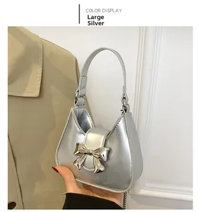 Detailed close-up of a silver metallic handbag with a large bow and chain strap
