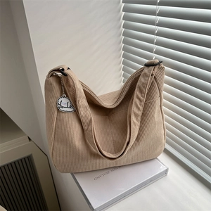 Minimalist beige corduroy tote bag with adjustable strap and cute dog pendant accessory