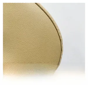 Gros plan sur la texture du cuir grainé doré champagne avec coutures de précision