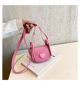 Detail showing pink mini saddle bag with heart ornament and adjustable strap