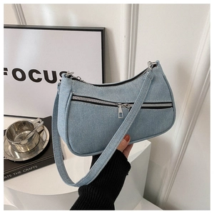 Dettaglio della borsa a mezzaluna in denim blu chiaro con finiture argentate e zip
