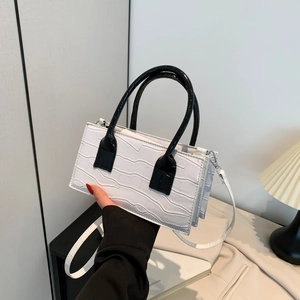 Fashionable white faux crocodile texture handbag with black handles and shoulder strap