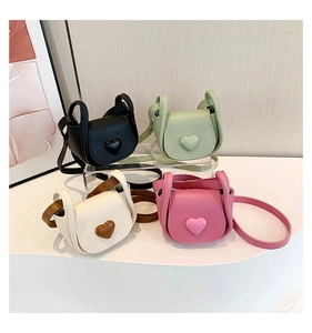 Detail view of four mini heart-shaped PU leather crossbody bags in assorted colors
