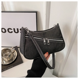 Dettaglio borsa a mezzaluna in denim grigio con doppie cerniere e tracolla in tessuto