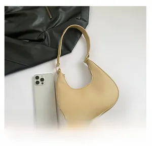 Vue de dessus sac hobo beige avec boucles dorées à côté d'un téléphone portable
